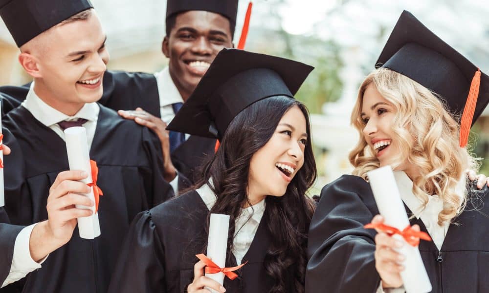 Five students in graduation caps and gowns