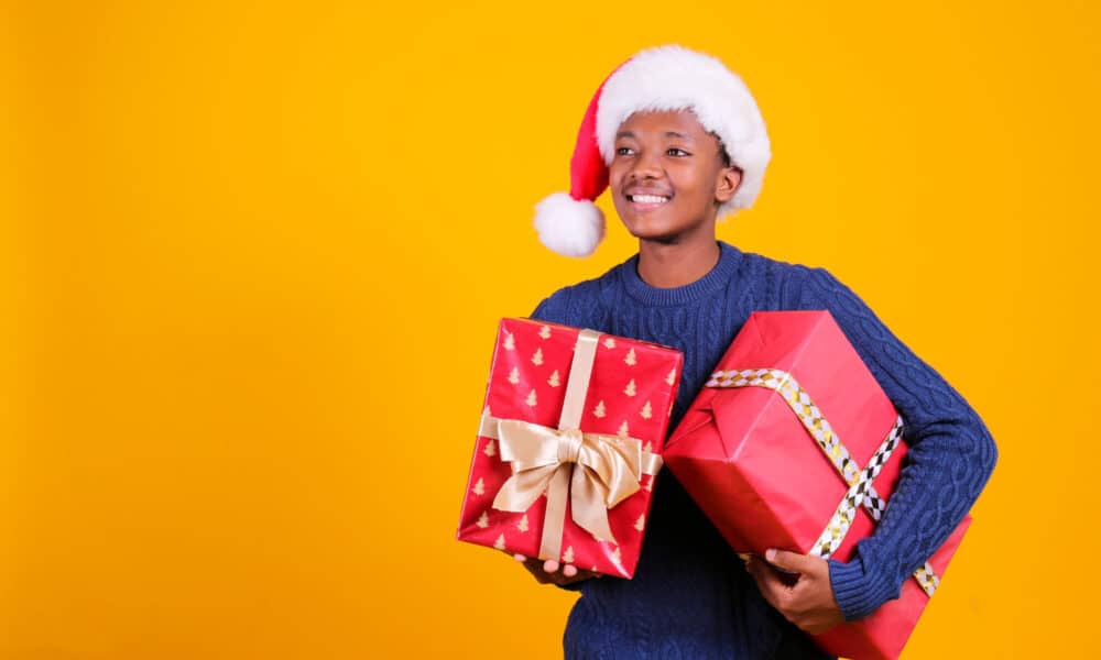 teenage boy holding gifts and smiling