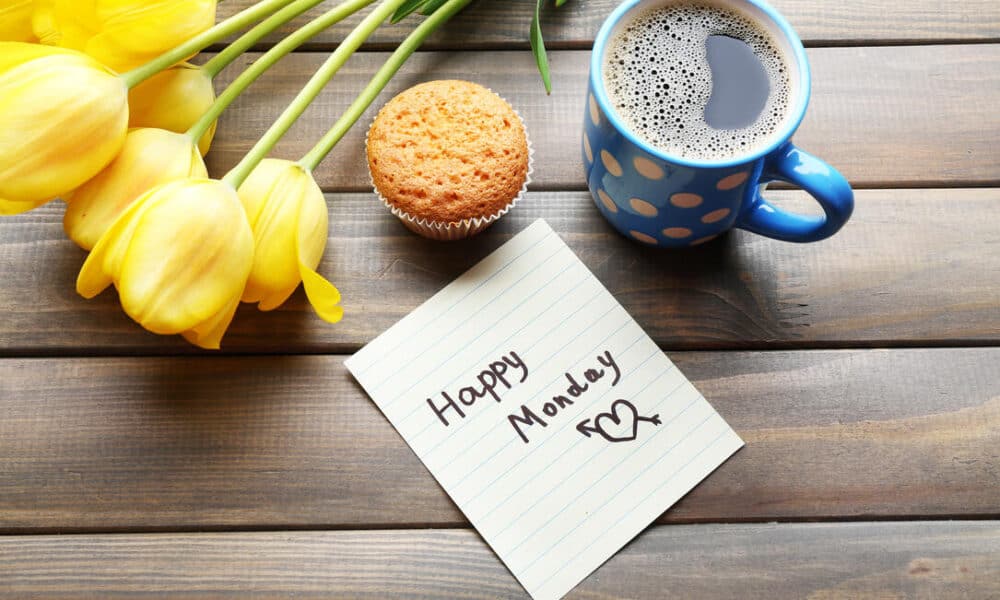 a cup of coffee with cupcake, tulips and happy monday message note